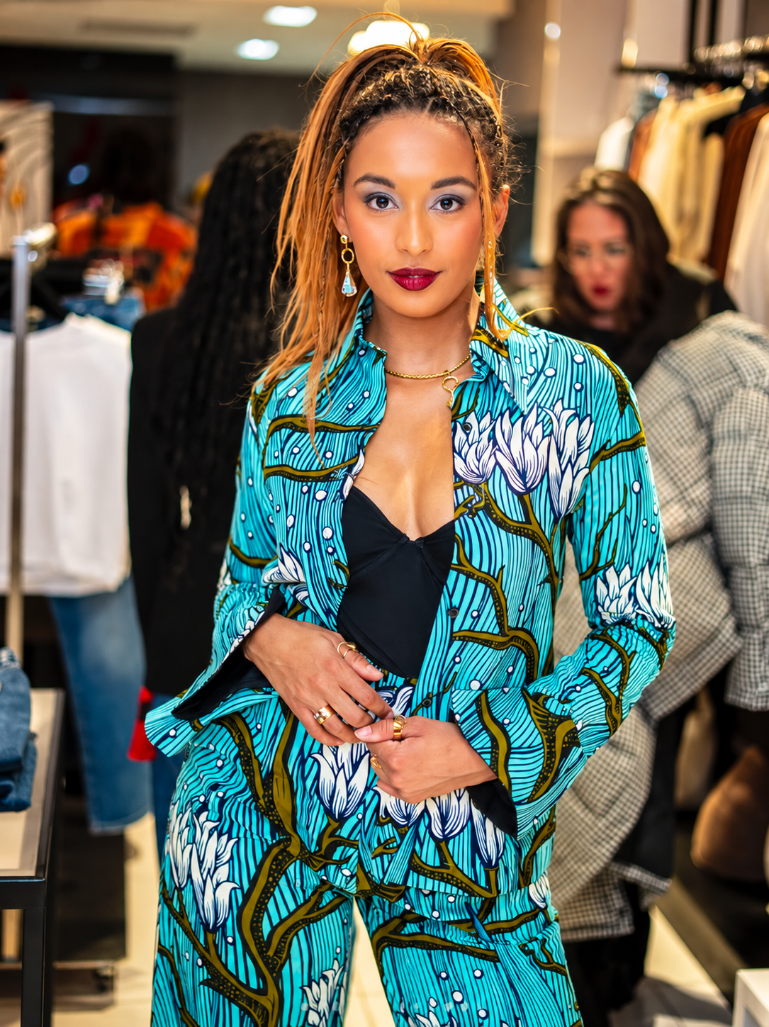 A confident customer wearing an expressive turquoise patterned suit inside the boutique